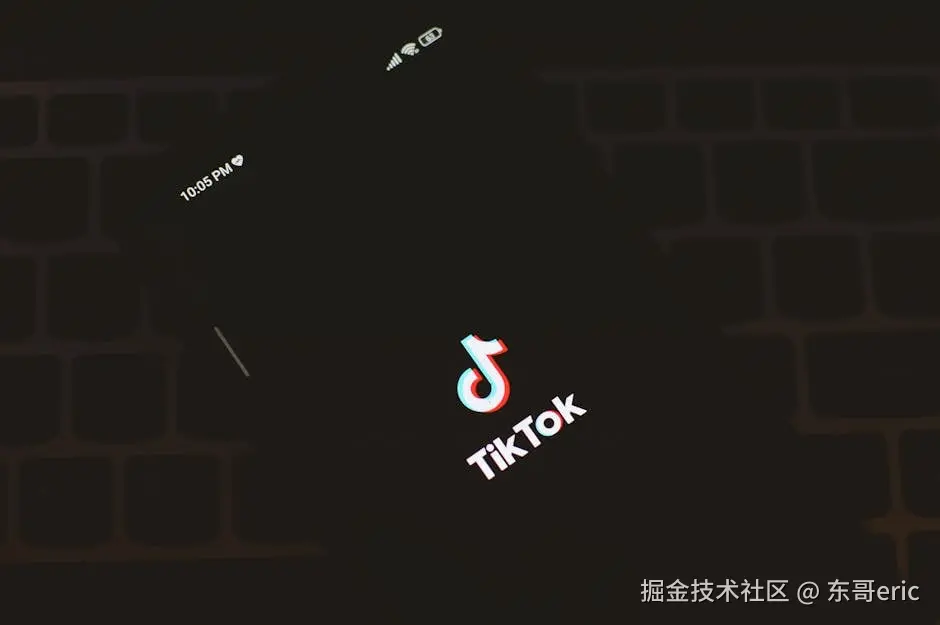 Close-up of a smartphone displaying the TikTok app logo against a dark keyboard 