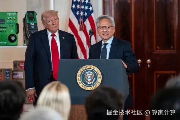 Jensen Huang, wearing a blue suit and tie, stands at a lectern bearing the presidential seal. President Trump, wearing a blue suit and red tie, stands to his right.